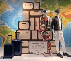 two mannequins are standing next to luggage in front of a map