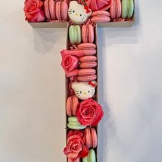 the letter t is made up of macaroons and roses with hello kitty on them