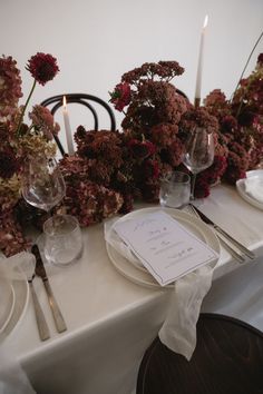 the table is set with flowers and candles