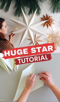 a woman is making a star out of paper and some christmas decorations on the wall