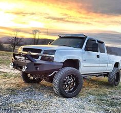 a white truck parked on top of a grass covered field