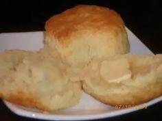 two pieces of bread on a white plate with buttered biscuits in the middle and one piece cut out