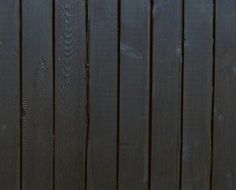 an orange and white cat sitting on top of a wooden bench next to a fence