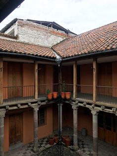 an open courtyard with potted plants on the balconies