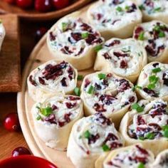 a platter filled with cranberry rolls on top of a wooden table