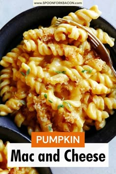 pumpkin macaroni and cheese in a black bowl with a fork on the side