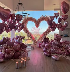 a room filled with lots of heart shaped balloons in the shape of hearts and flowers