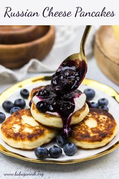 blueberry russian cheese pancakes on a plate with syrup being drizzled over them