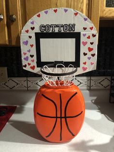 an orange basketball sitting on top of a white counter next to a basket with hearts