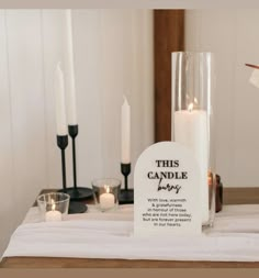 a table with candles and a sign that says, this candle is for baby on it