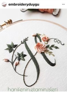 an embroidered monogram with flowers on it and the letter e is made from embroidery