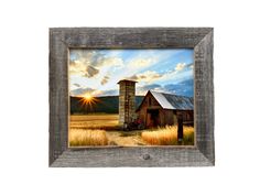 an old barn with the sun setting in the background, framed on a wooden frame