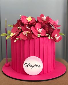 a pink cake with flowers on top and the name kaydeee written on it