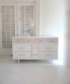 a white dresser with glass doors in a room