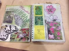 an open notebook with pictures of flowers and butterflies on it, sitting on a table