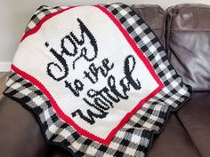 a crocheted christmas blanket with the words joy to be merry written on it