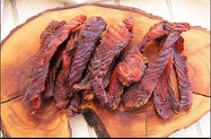 some meat is sitting on top of a piece of wood