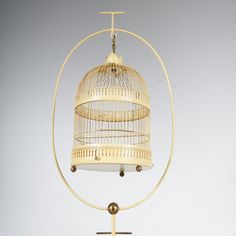 a white birdcage hanging from a metal stand