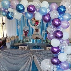 a table topped with lots of balloons and cake