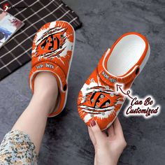 Introducing our Bengals Unisex Clogs Personalized CBengals Football Ripped Claw Clog Shoes, the ultimate footwear for all Bengals fans out there! Show your team spirit with these stylish and comfortable clogs that are perfect for game days, tailgating parties, or simply lounging around. These Bengals Unisex Clogs are not just your ordinary shoes – they are personalized with the iconic Bengals logo and feature a unique ripped claw design on the front. This attention to detail makes them stand out Clean Crocs, Cincinnati Bengals Football, Classic Crocs, Bengals Football, Crocs Clog, Clog Shoes, Wooden Shoes, Football Shoes, Shoe Gifts