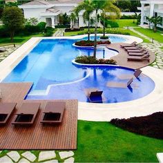 an outdoor swimming pool surrounded by lawn chairs