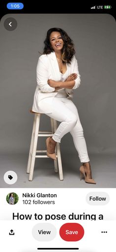 a woman sitting on top of a stool with her arms crossed and smiling at the camera