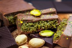 there are many pieces of chocolate with green toppings on the top and one piece has pistachio