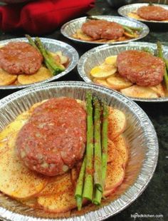 asparagus, potatoes and hamburgers on tin foil are ready to be served