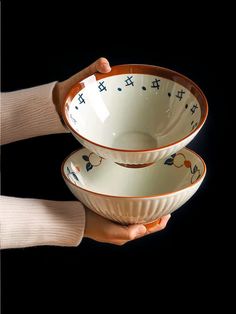 two people holding bowls in their hands