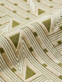 a close up view of a green and white fabric with geometric design on the side