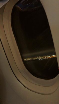 an airplane window looking out at the city lights