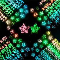 an image of colorful lights in the shape of stars on a black background with green and red colors