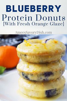 blueberry protein donuts with fresh orange glaze are stacked on top of each other