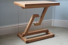 a wooden desk with glass shelves underneath it on the floor next to a chair and window