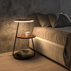 a table lamp sitting on top of a bed next to a night stand with a magazine