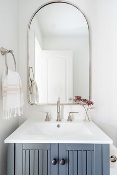 a bathroom sink with a mirror above it and a towel hanging on the wall next to it