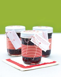 three jars of jam sitting on top of a red and white place mat next to each other