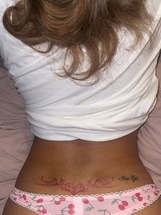 a woman with a tattoo on her stomach wearing pink panties and white t - shirt