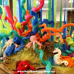 an arrangement of plastic toys and streamers in the shape of octopuses, corals, and seaweed