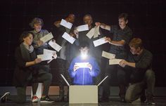 a group of people standing around a table with papers in front of them on top of it