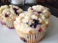 two blueberry muffins sitting on top of a white plate