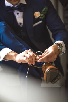 a man in a tuxedo tying his groom's shoes with the words guide to choosing your groomsmen