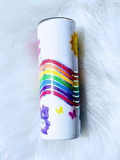 a white coffee cup with a rainbow painted on the side and stars in the background