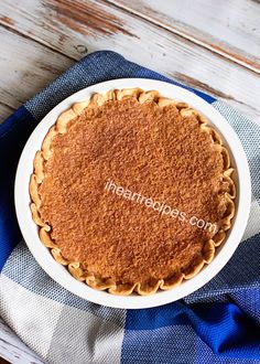 a pie sitting on top of a blue and white checkered cloth