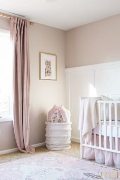 a baby's room with pink and white decor