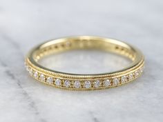 a yellow gold wedding band with white diamonds