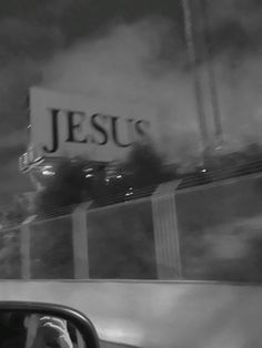 black and white photograph of jesus's sign in the back window of a car