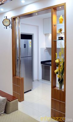 an open door leading to a kitchen and living room with a clock on the wall