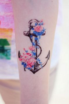 an anchor with flowers on the side of her leg is shown in this tattoo design