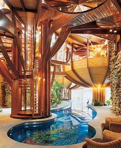 an indoor swimming pool in the middle of a living room with wooden walls and flooring